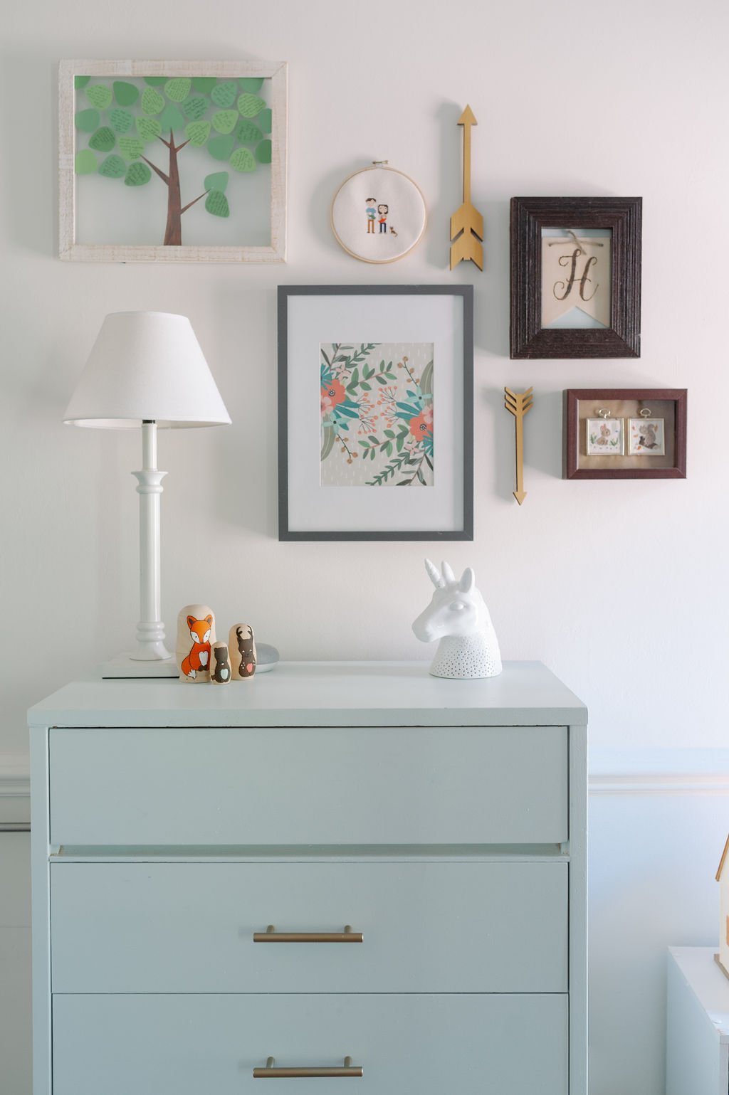Mint green dresser in little girls room with unicorn nightlight and gallery wall frames