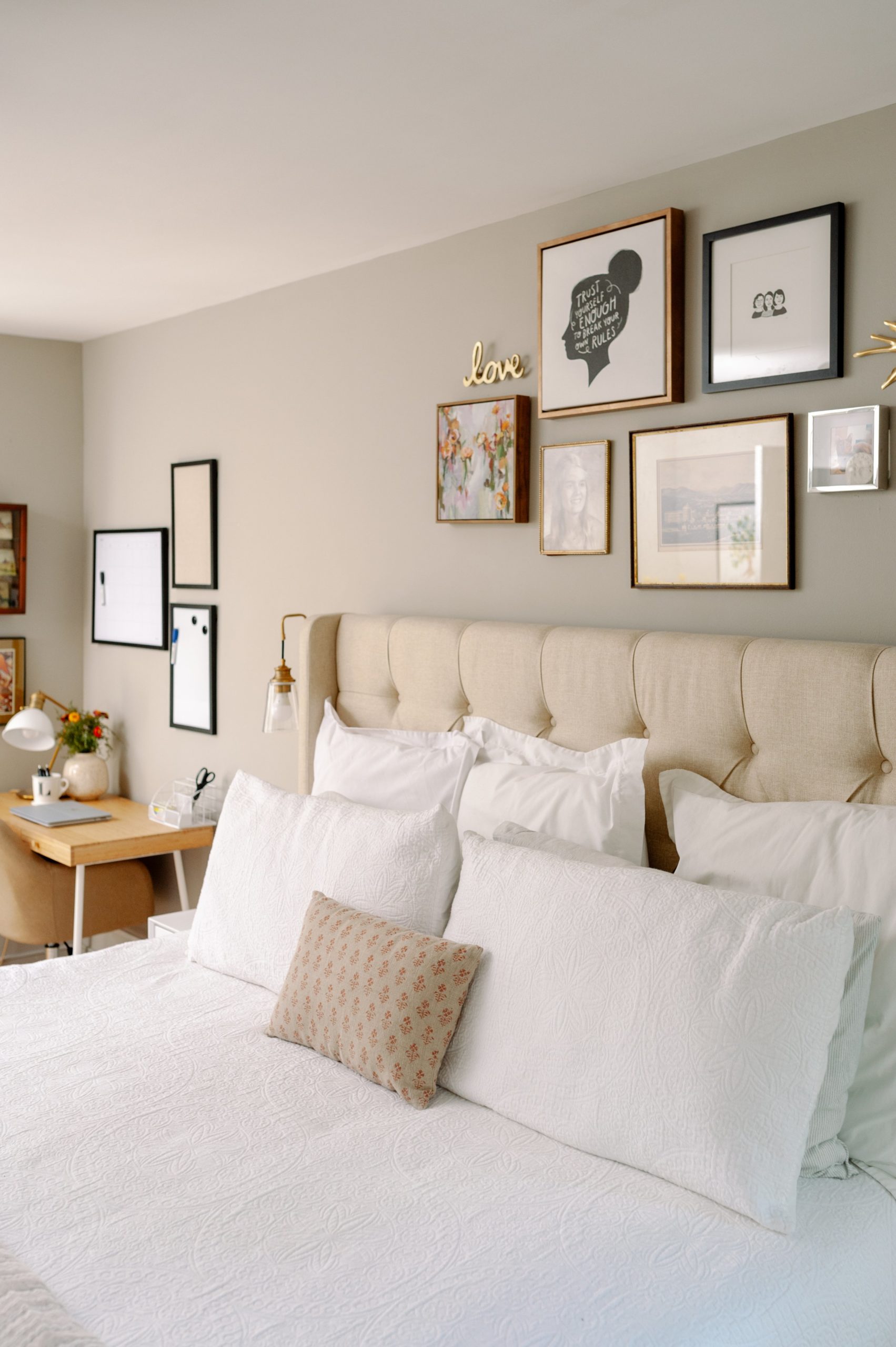 Sherwin Williams Mindful Gray Bedroom with Gallery Wall and Upholstered Beige Headboard; office in bedroom