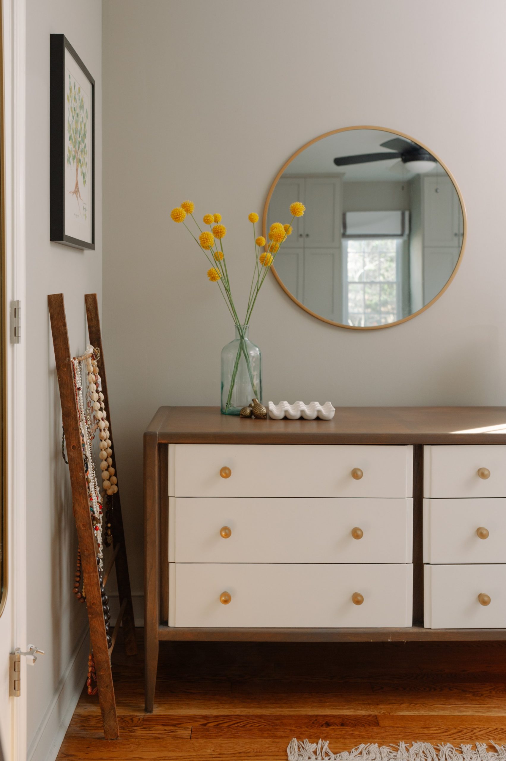 Upcycled two tone midcentury dresser, round brass mirror, yellow flowers, creative jewelry storage